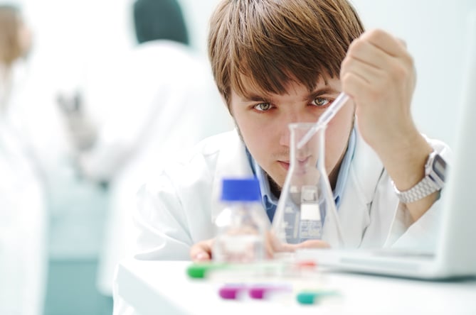 Young medical scientist working in modern lab, research with tubes and notebook